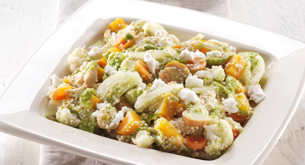 Warm royal quinoa salad with crunchy vegetables and herb pesto